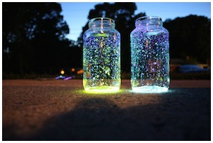 Two jars placed outdoors at night, filled with flecks of color and symbolizing the magic of learning, by Engel Tutors.